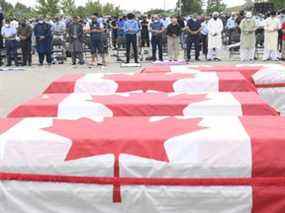 Les personnes en deuil prient alors que des cercueils drapés de drapeaux canadiens sont alignés lors des funérailles des quatre membres de la famille musulmane tués lors d'une attaque mortelle à la voiture, au Centre islamique du sud-ouest de l'Ontario à London, en Ontario, le samedi 12 juin 2021. Talat Afzaal , 74 ans, son fils Salman Afzaal, 46 ans, sa femme Madiha Salman, 44 ans, et leur fille de 15 ans, Yumna Salman, sont tous morts dimanche soir dernier alors qu'ils se promenaient après qu'un homme dans un camion les a conduits dans ce que la police a qualifié d'attaque préméditée parce qu'ils étaient musulmans.