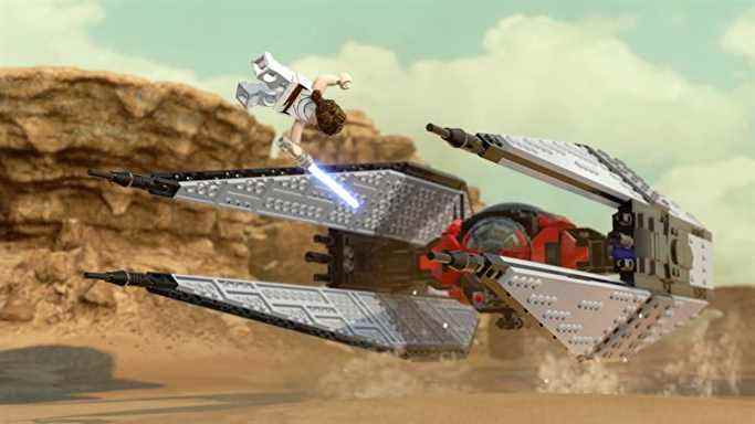 Lego Rey saute par-dessus un Tie Fighter sur le sable de Tatooine dans Lego Star Wars The Skywalker Saga
