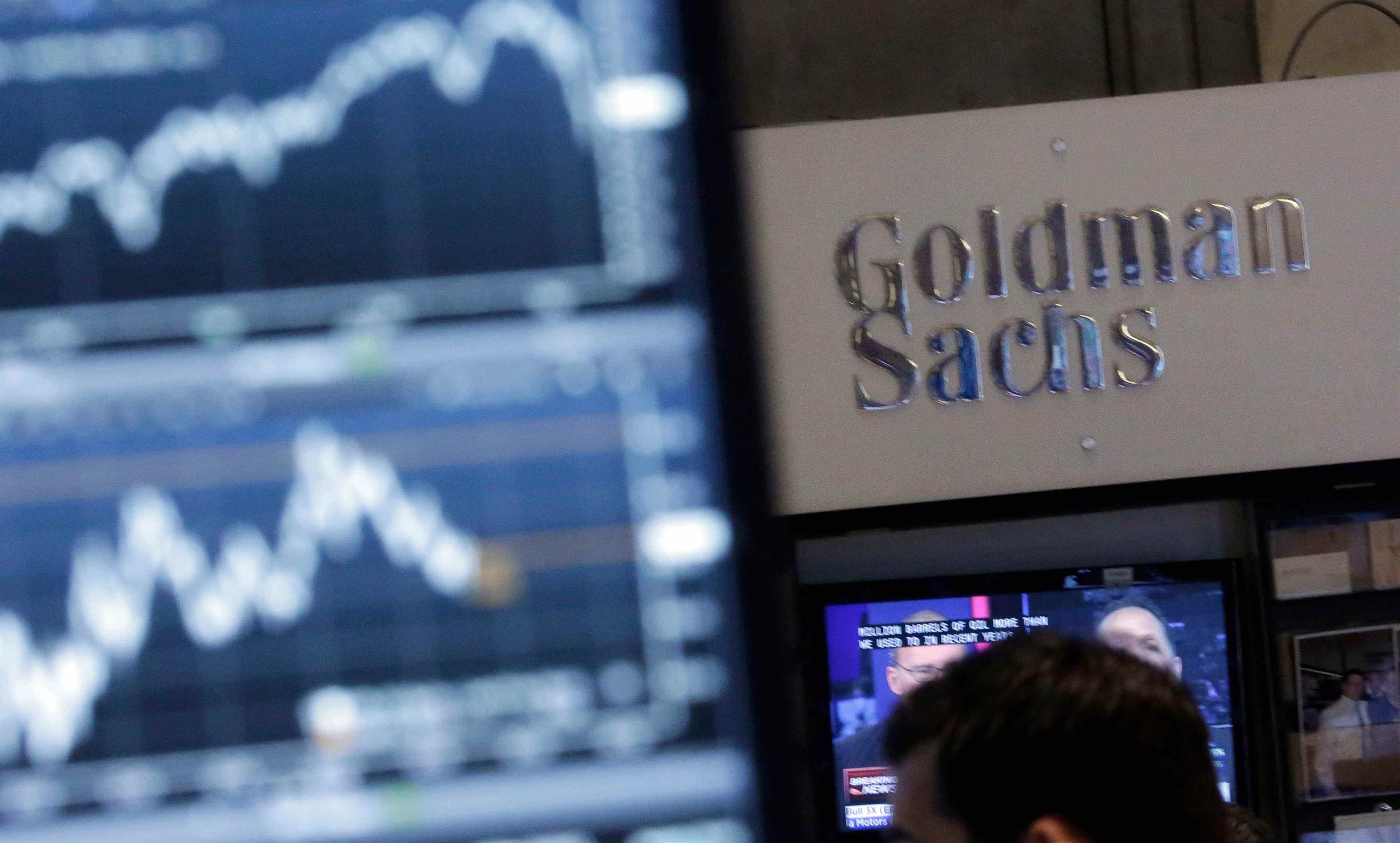 Une image d'un écran à un poste de traite sur le parquet de la Bourse de New York est juxtaposée au stand de Goldman Sachs