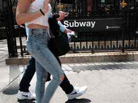 Les gens marchent près d'une station de métro dans un centre-ville animé de Manhattan le 13 avril 2022 à New York.