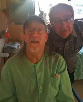 Alan Nichols en vert dans sa chambre d'hôpital juste avant sa mort, avec son frère, Gary, à ses côtés.