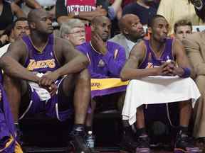 Shaquille O'Neal, à gauche, Gary Payton, au centre, et Kobe Bryant des Lakers de Los Angeles regardent depuis le banc lors du quatrième quart du cinquième match de la finale de la NBA 2004 contre les Pistons de Detroit le 15 juin 2004 au Palais de Auburn Hills à Auburn Hills, Michigan.