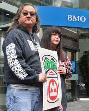 Maxwell Johnson avec la chef Heiltsuk Marilyn Slett devant la succursale de la rue Burrard de la Banque de Montréal.