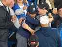 Un jeune fan des Yankees pleure des larmes de joie après qu'un fan des Blue Jays lui ait donné un ballon de home run d'Aaron Judge lors du match Yankees-Blue Jays au Rogers Center le mardi 3 mai 2022.