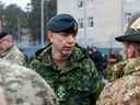 Le général Wayne Donald Eyre (C), chef d'état-major de la Défense canadienne (CEMD) s'entretient avec des soldats sur une base militaire, au nord-est de Riga, en Lettonie, le 8 mars 2022. (Photo de Toms Norde / AFP)