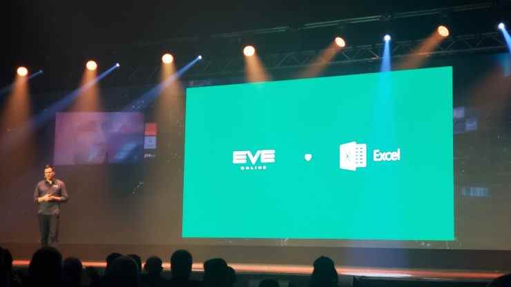 Le directeur créatif d'Eve Online, Bergur Finnbogasson, se tient à côté d'une grande diapositive verte sur laquelle on peut lire « EVE aime Excel »