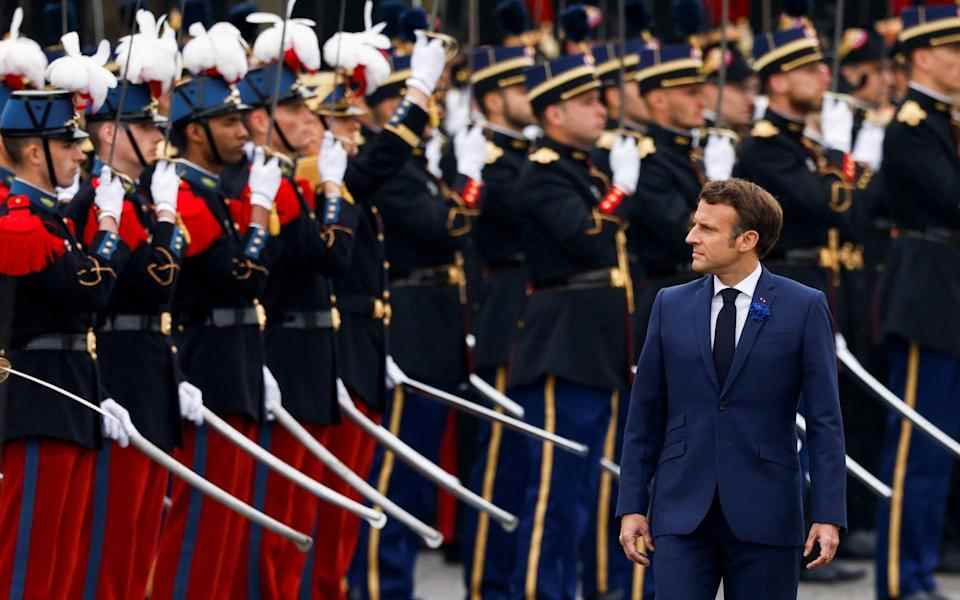 Le président français Emmanuel Macron passe en revue les troupes lors d'une cérémonie marquant la fin de la Seconde Guerre mondiale à l'Arc de Triomphe à Paris - GONZALO FUENTES/Reuters