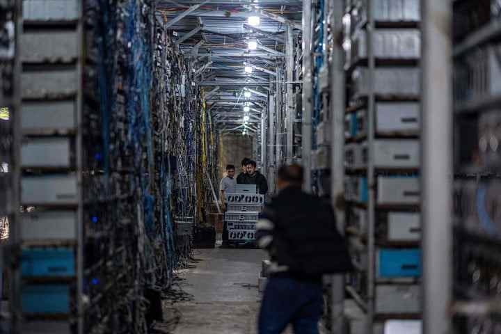 Les travailleurs transfèrent des plates-formes minières de crypto-monnaie dans une ferme de crypto-monnaie .