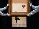 LONDRES, ANGLETERRE - 12 OCTOBRE : les employés de Sotheby's posent avec « Love is in the Bin » de l'artiste britannique Banksy lors d'un aperçu médiatique à la maison de vente aux enchères Sotheby's le 12 octobre 2018 à Londres, Royaume-Uni.  Lors de la vente d'art contemporain de Sotheby's le 5 octobre, l'œuvre d'art de Banksy 