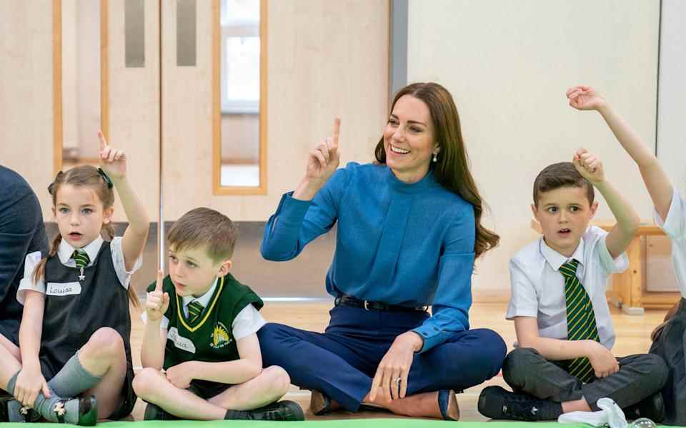 La duchesse de Cambridge est assise les jambes croisées alors qu'elle se joint à des comptines avec des élèves - Jane Barlow / PA