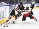 Shane Wright (15 ans) du Canada affronte l'Autrichien Tobias Sablattnig lors d'un match du Championnat mondial de hockey junior en décembre.