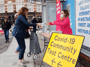 Une femme reçoit un kit de test rapide COVID-19 gratuit à Londres, en Angleterre.