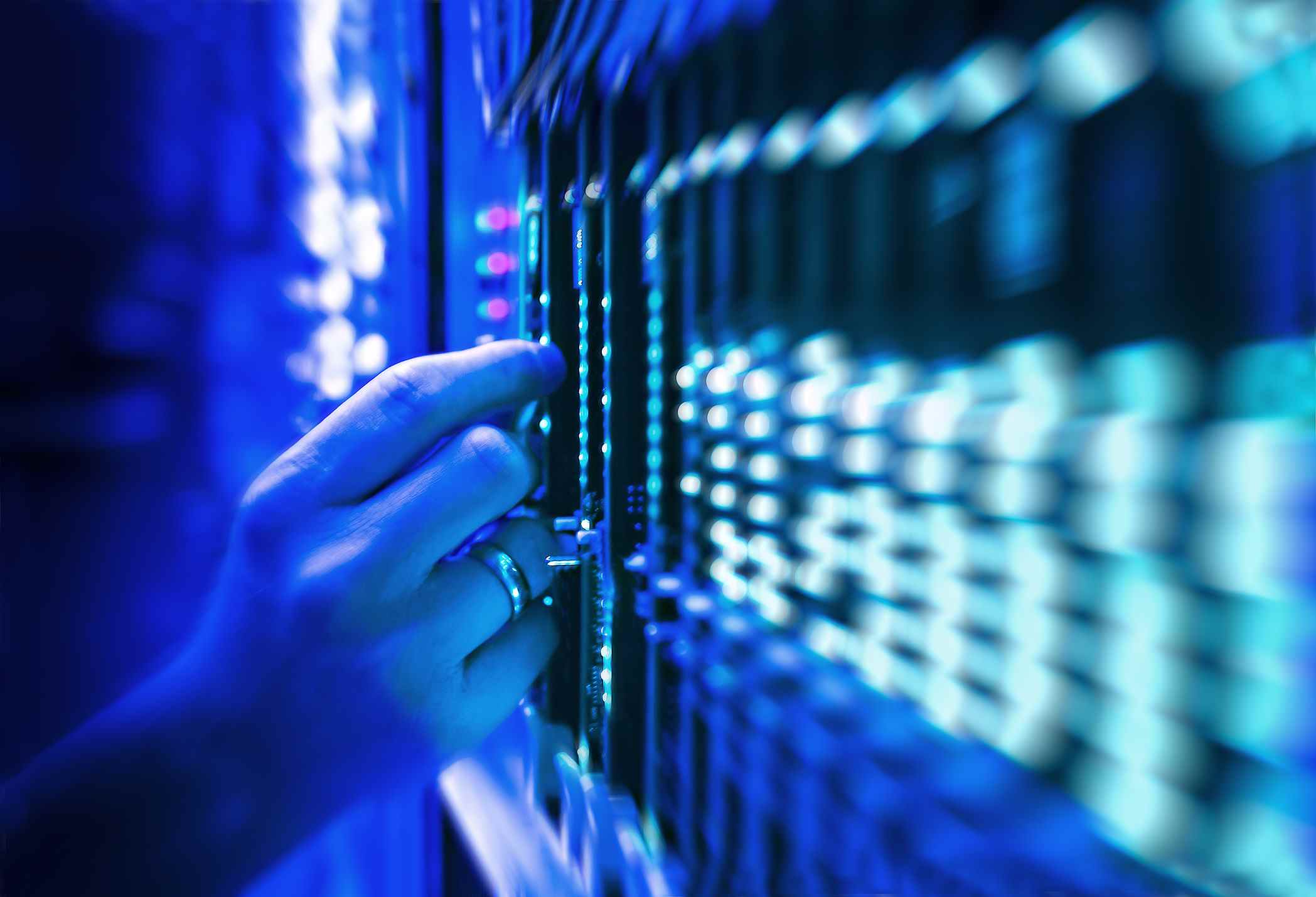 technicien de serveur de réseau dans un centre de données baigné de lumière bleue