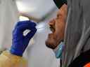 Des agents de santé provinciaux effectuent des tests d'écouvillonnage nasal pour la maladie à coronavirus (COVID-19) sur Raymond Robins de la communauté éloignée des Premières Nations de Gull Bay, Ontario, Canada, le 27 avril 2020. 