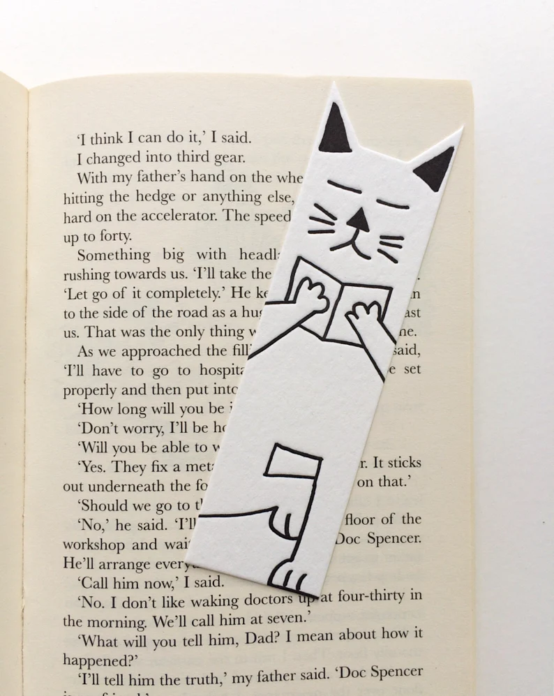 Image d'un signet de chat blanc à l'intérieur d'un livre ouvert,