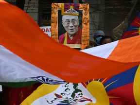 Des militants tiennent un portrait du 11e Panchen Lama, Gedhun Choekyi Nyima, et agitent les drapeaux du Tibet et de l'Inde lors d'une manifestation contre l'invasion chinoise du Tibet, à Calcutta le 23 avril 2022.