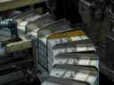 Des piles d'argent circulent dans une machine lors de la production de nouveaux billets de 100 dollars américains.