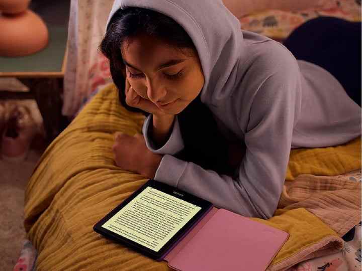 Une fille lisant un e-book sur Amazon Kindle Paperwhite Kids.