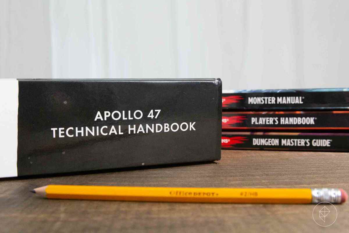 Le manuel technique d'Apollo 47 à côté du manuel du joueur, du DMG et du manuel Monster.  Il mesure un demi-pouce de plus que les trois.
