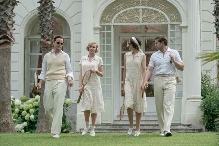 Quatre adultes marchent sur une pelouse verte dans Downton Abbey : A New Era.