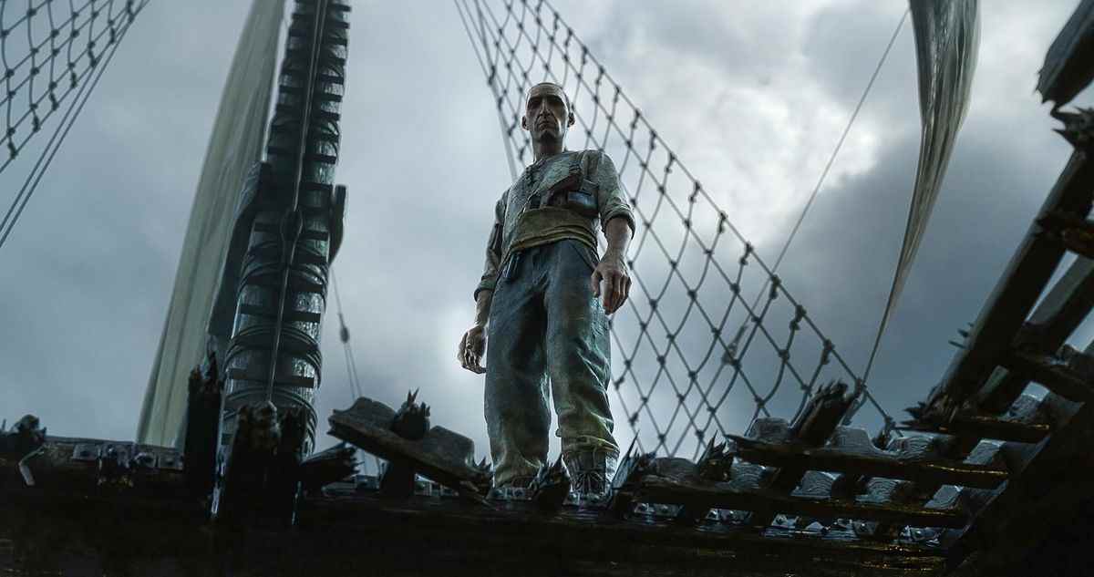 un homme se tient au-dessus du brick d'un voilier