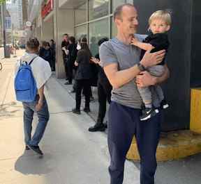Braden Fox et son fils Ethan attendent pour essayer d'obtenir des passeports.  Scott Laurie/Toronto Sun