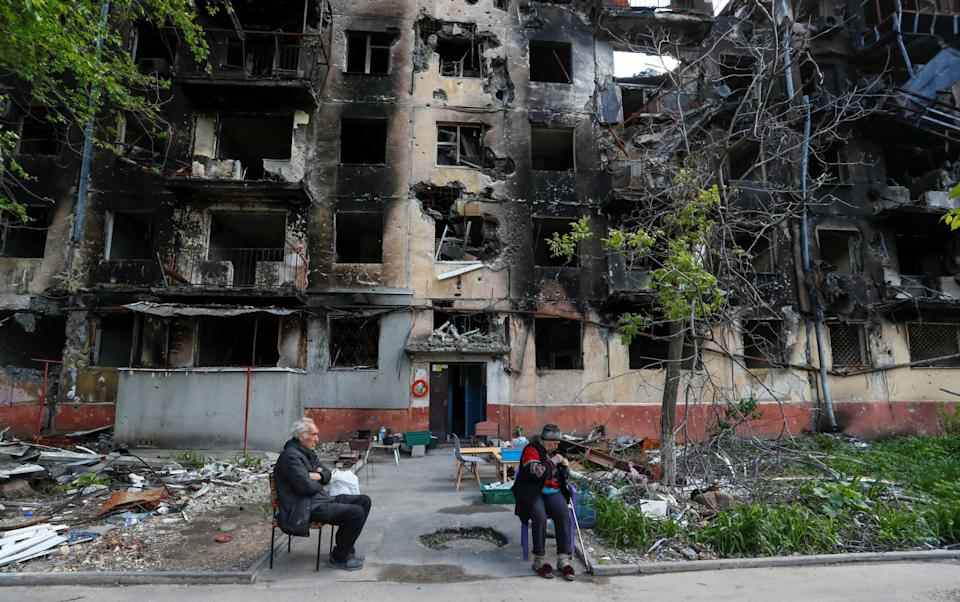 Les résidents âgés de Marioupol sont assis dans une cour près d'un immeuble détruit par les Russes - REUTERS/Alexander Ermochenko