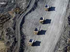 Des camions à benne chargés de sables bitumineux traversent la mine Suncor Energy Inc. près de Fort McMurray.