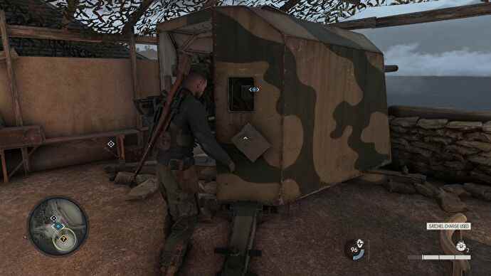 Capture d'écran de Sniper Elite 5 du personnage principal plantant une charge explosive sur une grande tourelle dans un bunker
