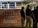 Les agents des forces de l'ordre parlent ensemble à l'extérieur de l'école élémentaire Robb après la fusillade de masse à l'école élémentaire Robb le 24 mai 2022 à Uvalde, au Texas. 