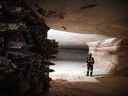 Un mineur se tient près de la tête de coupe d'une excavatrice près d'un mur minier actif à la mine de potasse Nutrien Ltd. Cory à Saskatoon.