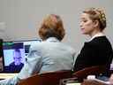 L'acteur Amber Heard regarde un témoignage de déposition préenregistré de l'avocat Adam Waldman apparaître sur l'écran lors du procès en diffamation de l'ex-mari Johnny Depp contre elle au tribunal de circuit du comté de Fairfax à Fairfax, Virginie, le 19 mai 2022.