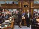 Les députés de l'Assemblée législative du Québec applaudissent Véronique Hivon, gauche et ancien ministre de la Santé du Québec, Gaétan Barrette, le jeudi 22 mai 2014 à Québec.  Les deux députés ont décidé de ne pas se représenter à l'automne.