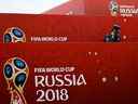 Un membre du ministère russe des Urgences parle sur son smartphone tout en surveillant le parc de football sur le thème de la Coupe du Monde de la FIFA, Russie 2018 sur la Place Rouge à Moscou le 10 juillet 2018, à la veille de la demi-finale de la Coupe du Monde de football Russie 2018 entre la Croatie et l'Angleterre. 