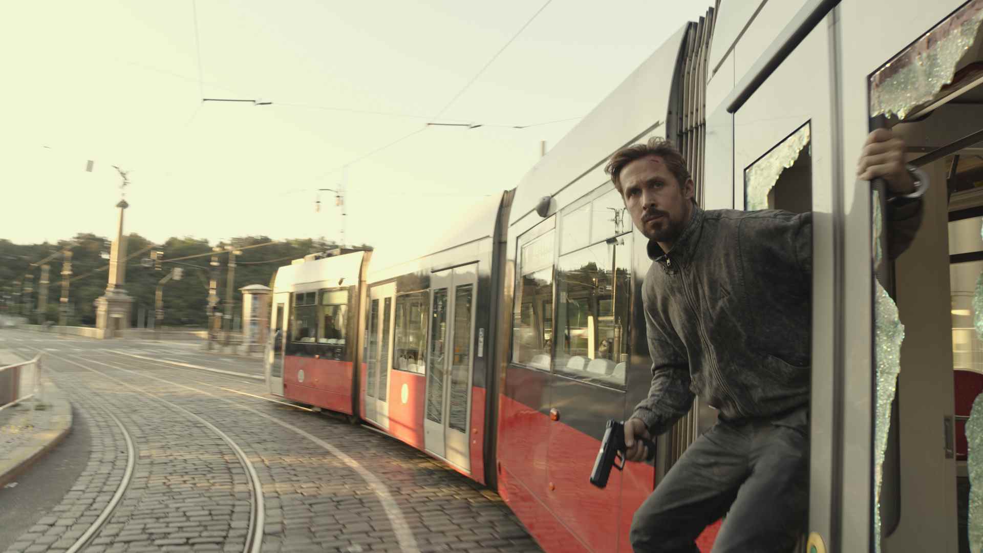 La Sierra Six de Ryan Gosling accrochée au flanc d'un train, arme à la main, dans The Grey Man