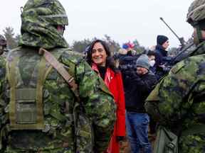 La ministre de la Défense du Canada, Anita Anand, s'entretient avec des soldats lors d'une visite de la base militaire d'Adazi, au nord-est de Riga, en Lettonie, le 8 mars 2022.