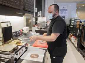 Karam Gebran prépare un sandwich à son Café, Les Moulins La Fayette, à Montréal, le 31 janvier 2022.