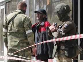 Un civil qui a quitté la zone près de l'aciérie d'Azovstal à Marioupol s'entretient avec des militaires pro-russes près d'un centre d'hébergement temporaire dans la région de Donetsk en Ukraine le 1er mai 2022.