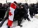 Des policiers affrontent des manifestants à Ottawa, le 19 février.