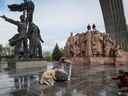 Les gens prennent des photos d'un monument soviétique à l'amitié entre les nations ukrainiennes et russes lors de sa démolition, à Kiev le 26 avril 2022. 