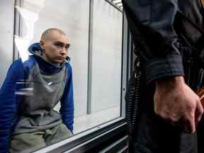 Le soldat russe Vadim Shishimarin, 21 ans, soupçonné de violations des lois et normes de la guerre, est assis dans la cage des accusés lors d'une audience au tribunal, au milieu de l'invasion russe de l'Ukraine, à Kiev, en Ukraine, le 13 mai 2022.