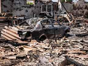 Cette photo prise le 11 mai 2022 montre une voiture et un tracteur incendiés après un bombardement par les forces russes dans la ville d'Orikhiv, près de Zaporizhzhia, dans l'est de l'Ukraine.
