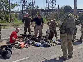 Des militaires des forces ukrainiennes qui se sont rendus après des semaines enfermés dans les aciéries d'Azovstal sont recherchés par l'armée pro-russe à Marioupol, en Ukraine, sur cette image fixe tirée d'une vidéo publiée le 18 mai 2022.