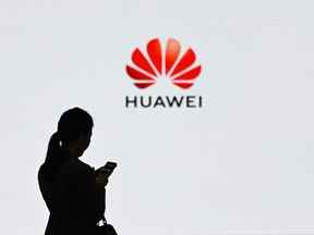 Un membre du personnel de Huawei utilise son téléphone portable lors de la vitrine de la transformation numérique de Huawei à Shenzhen, en Chine.