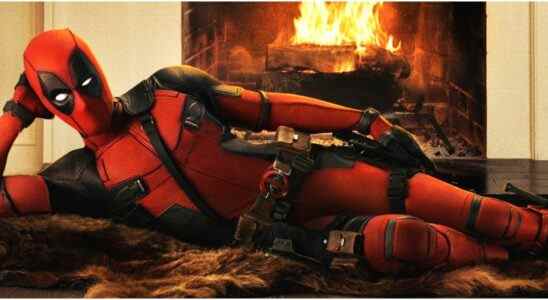 Deadpool (Ryan Reynolds) lies seductively on a bearskin rug in front of a fire