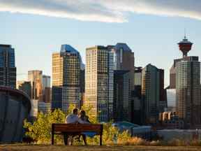 Un jeune couple partage un moment romantique juste avant que le soleil ne se couche derrière la ligne d'horizon de Calgary.
