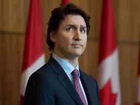 Le premier ministre Justin Trudeau regarde un écran géant pendant que le ministre de l'Immigration, des Réfugiés et de la Citoyenneté, Sean Fraser, s'exprime par vidéo lors d'une conférence de presse à Ottawa, le vendredi 25 février 2022.