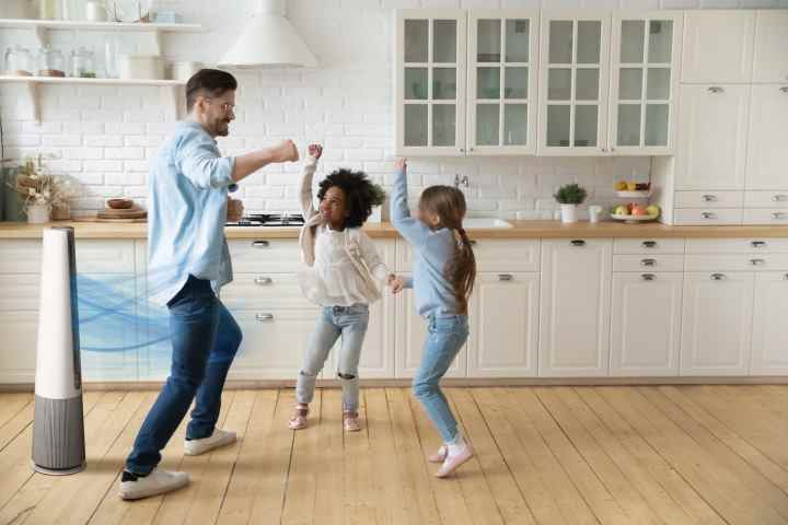 Un homme et deux enfants dansent dans la cuisine à côté de l'AeroTower.