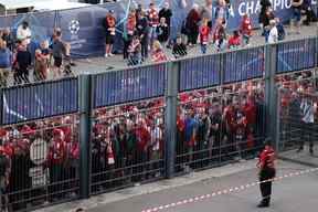 Les supporters de Liverpool se tiennent à l'extérieur avant le match de football de la finale de l'UEFA Champions League entre Liverpool et le Real Madrid au Stade de France à Saint-Denis, au nord de Paris, le 28 mai 2022. (Photo de Thomas COEX / AFP)