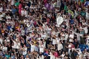 Les supporters du Real Madrid célèbrent la 14e Coupe d'Europe de leur équipe le 29 mai 2022 au stade Santiago Bernabeu de Madrid, un jour après avoir battu Liverpool en finale de l'UEFA Champions League à Paris.  (Photo par OSCAR DEL POZO/AFP via Getty Images)